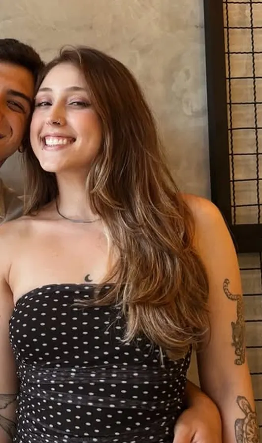 Isabela Rosse sorrindo, com tatuagens no braço